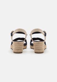 Mørkeblå espadrillesandaler med vevde tekstilremmer, justerbare ankelspenner og juteomviklede kilehæler.