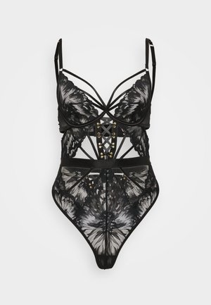 Body in pizzo nero con motivi floreali, dettagli a strappi, coppe con stecche e una parte frontale allacciata in stile corsetto su uno sfondo bianco.