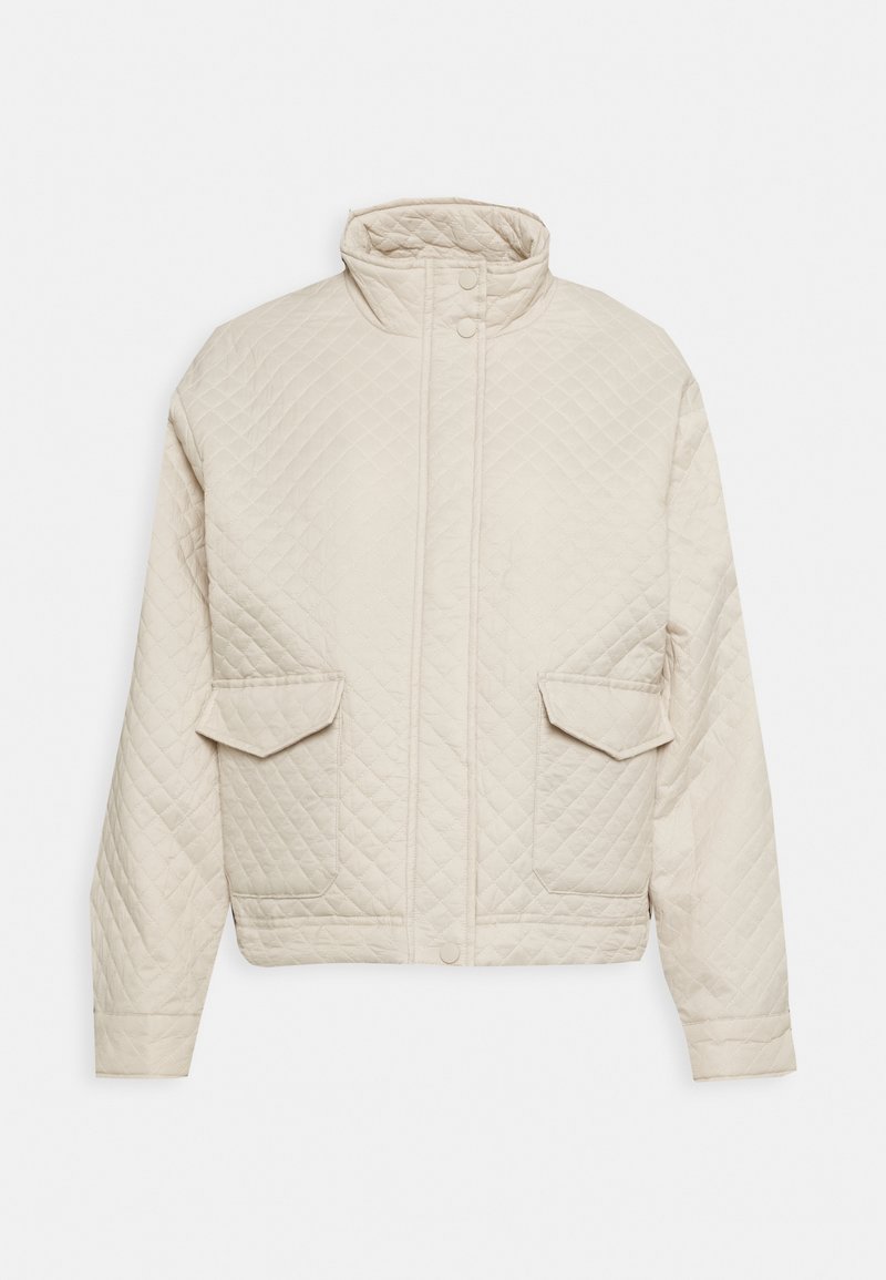 Veste matelassée beige avec col montant, manches longues, deux poches avant à rabat et fermeture par boutons-pression.