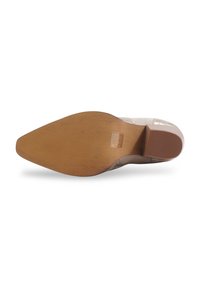 Chaussure à talons hauts avec un bout pointu, tige synthétique beige et une semelle en caoutchouc texturé brun avec un motif en zigzag.