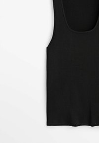 Débardeur noir à côtes, avec de larges emmanchures et un décolleté plongeant. Le tissu présente un motif texturé, offrant une silhouette ajustée.