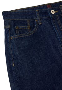 Vaqueros de mezclilla oscura con costuras amarillas en contraste, diseño de cinco bolsillos y cierre de botón metálico en la cintura. Textura suave.