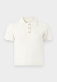 Άσπρο πόλο μπλουζάκι με κοντά μανίκια από απαλό ύφασμα και ριμπ γιακά, διακοσμημένο με τρία κρυσταλλικά κουμπιά στο φιόγκο.