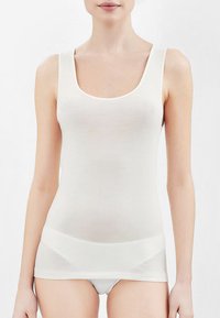 Top bianco senza maniche con scollatura a girocollo e spalline sottili. Realizzato in un tessuto morbido ed elastico, presenta un design aderente e bordi senza cuciture.
