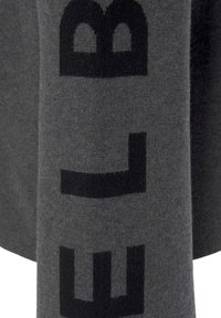 Grau gestrickter Stoff mit einer weichen Textur, auf dem große schwarze Buchstaben gedruckt sind. Das Design umfasst fett gedruckte, grafische Schriftzüge.