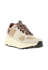 Beige sneaker with a textured upper, contrasting maroon accents, and a chunky speckled sole. Features patterned laces and reinforced heel.