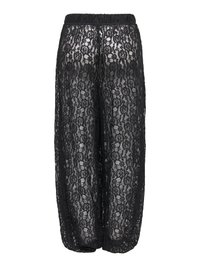 Fekete, áttetsző csipkés, bő szárú nadrág gumis derékpánttal és virágmintával, teljesen átlátszó, alatta fehér anyagot mutat.