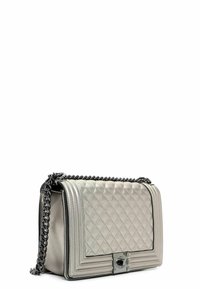 Bolso de mano plateado acolchado con forma rectangular, cadena negra, herrajes metálicos y acentos texturizados en el cuerpo.