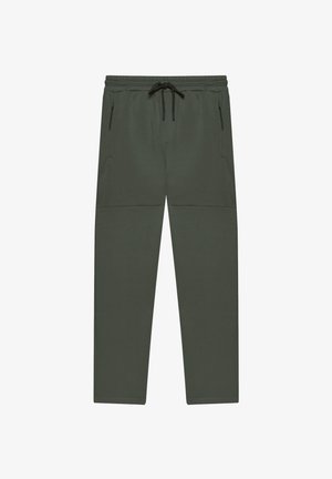 Ciemnozielone zwężane spodnie z elastycznym pasem, czarnym sznurkiem do ściągania oraz zapinanymi na zamek bocznymi kieszeniami, przedstawione płasko na białym tle.