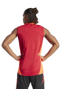 Maglietta atletica senza maniche in rosso e arancione, caratterizzata da un tessuto liscio, scollo rotondo e un design a pannelli laterali a contrasto.