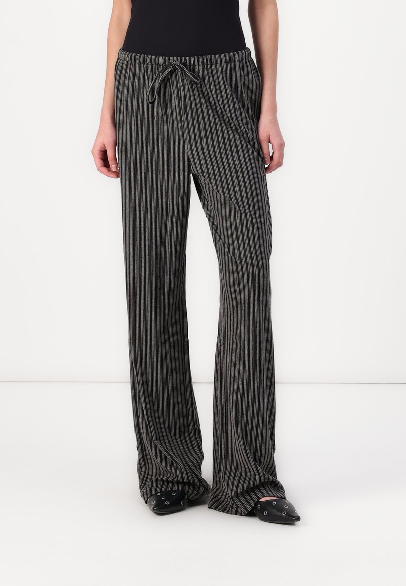 Pantalons légers à rayures noires et grises avec une taille élastique, un cordon de serrage et une coupe large, en tissu doux et texturé.