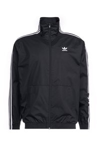 Svart zip-up jacka i slätt, lättviktigt material. Har vita tre-stripes detaljer längs ärmarna och en liten logotyp på bröstet.