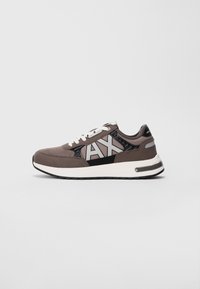 Sneaker grigio e nero a taglio basso con lacci bianchi, suola bianca e grande logo "AX" sul lato.