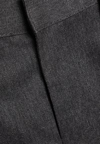Tissu gris foncé avec un tissage texturé, présentant une finition lisse et un subtil détail de couture. Deux sections repliées distinctes visibles.