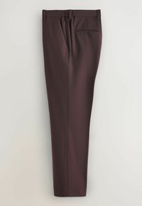 Pantalon habillé sur mesure de couleur marron foncé avec une poche arrière boutonnée, des passants pour ceinture et un pli sur le devant de chaque jambe.