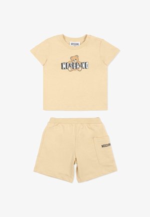 Beige peuter T-shirt en korte broek set met een teddybeer afbeelding en "MOSCHINO" tekst op het shirt en de zak.