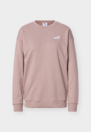 Sudadera de cuello redondo color malva claro con mangas largas y logo blanco de Puma en el pecho izquierdo, mostrada sobre un fondo liso.