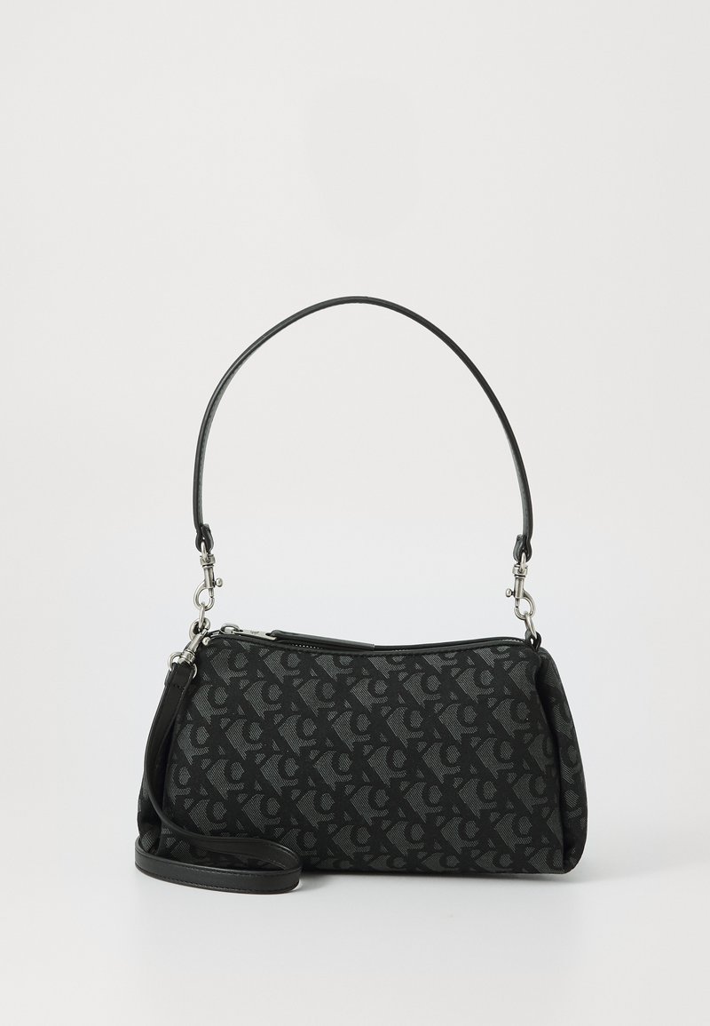 Black handbag made of patterned fabric with a zip closure. Features a single top handle and a detachable shoulder strap in black leather.