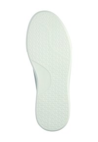 Valkoisen tennarin pohja, jossa on kuvioitu pito ja näkyvissä kaarevan muotoinen jalkakaari.