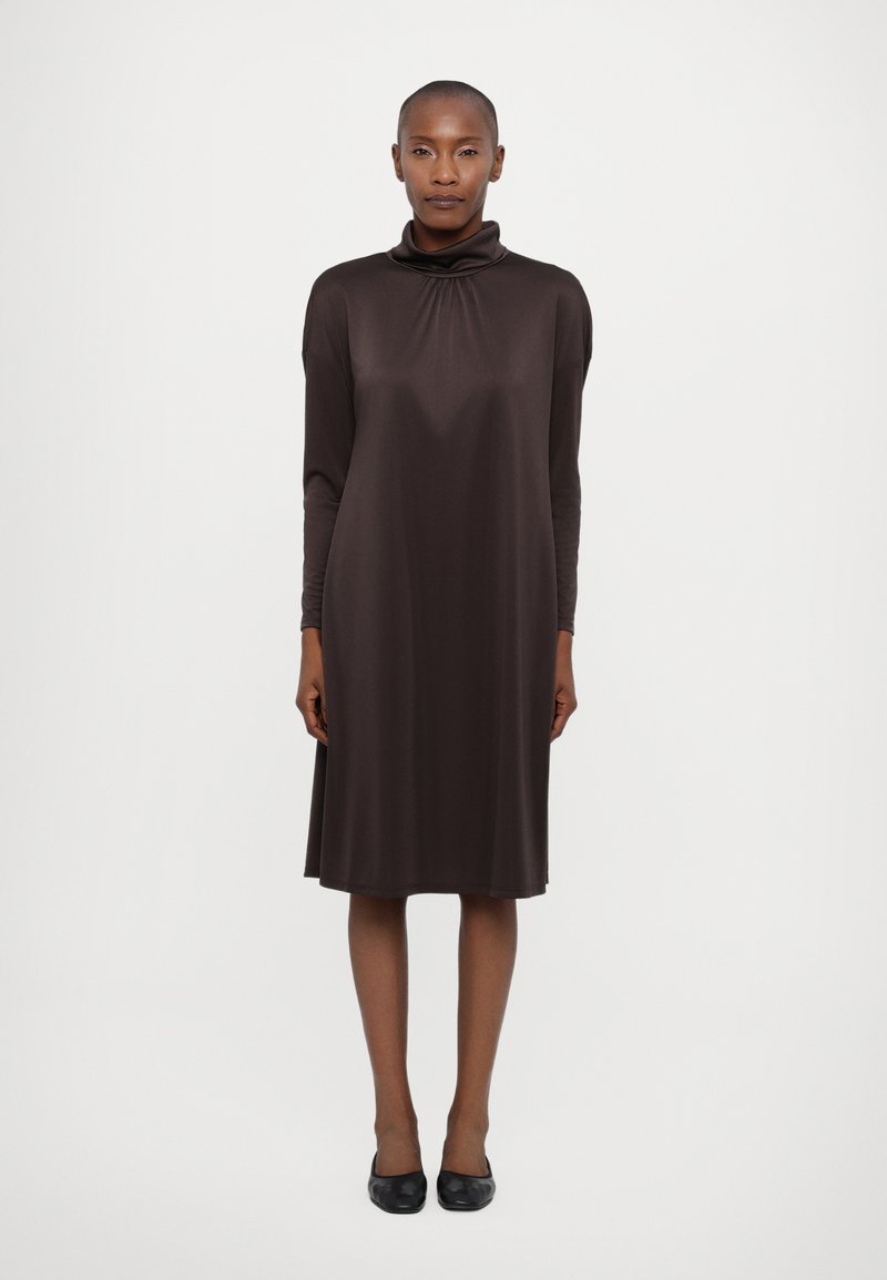 Abito lungo marrone con maniche lunghe e collo alto, caratterizzato da una vestibilità comoda e una texture liscia, che arriva poco sopra il ginocchio.