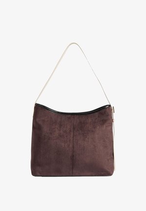 Brun ruskindtaske med sort kant og justerbar lys beige skulderrem, rektangulær form med en let buet topkant.
