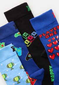 Quatro pares de meias de algodão: azuis com troféus, pretas com comandos de jogos, azul claro com ícones e azul escuro com o texto "JOGADOR UM".