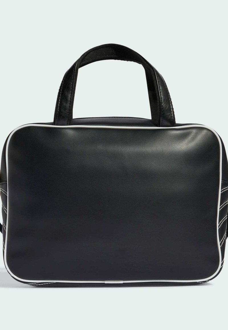 Sac en cuir rectangulaire noir avec passepoil blanc, deux petites poignées et couture latérale visible sur un fond clair.