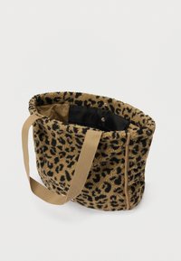 Geantă moale tip tote, cu un exterior în imprimeu leopard cu nuanțe de bej și negru, mânere din material bej și un buzunar interior cu capse negre, pe un fundal alb.