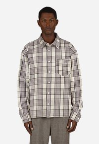 Knappskjorte i rutete mønster i beige og brune toner, med lange ermer, brystlomme og en myk, teksturert stofffinish.