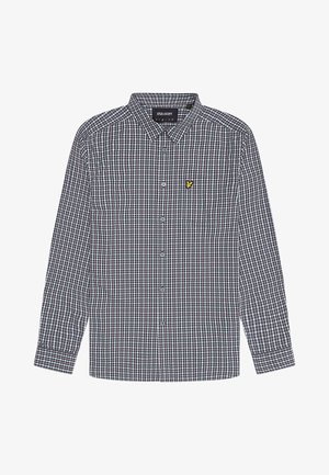 Rutigt skjorta i blått, vitt och svart med knäppning fram, långa ärmar och en liten gul logotyp på bröstfickan.