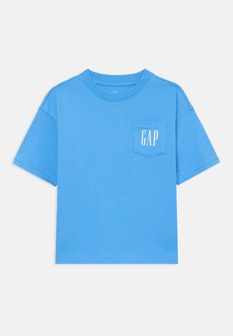 T-shirt de algodão azul com decote redondo e mangas curtas. Apresenta um bolso frontal com "GAP" impresso em branco. Textura suave.