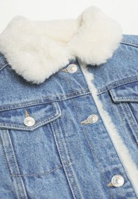 Denimjacka med vit fuskpälskrage, utrustad med silverfärgade tryckknappar, två bröstfickor och blått tyg med en strukturerad yta.