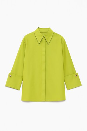 Chemise à manches longues vert citron avec col pointu, coupe droite et poignets boutonnés ornés d'un détail de garniture contrastante.