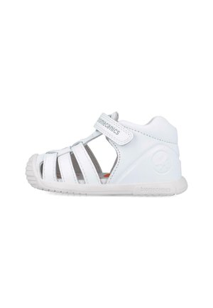 Sandalias blancas para niños con correa ajustable de Velcro, múltiples secciones con cortes para transpirabilidad y suela de goma texturizada para un buen agarre.