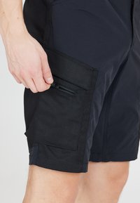 Laadukkaita tummansinisiä cargo-shortseja, joissa on vetoketjullinen sivutasku. Shortsien kankaassa yhdistyvät sileät ja kestävämmät tekstuurit, muotoiltu istuvuus sekä vahvistetut saumat.