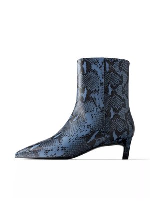 Bottine montant à la cheville avec bout pointu et petit talon kitten, ornée d’un motif en cuir de serpent bleu et noir.