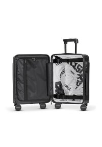 Czarna walizka na twardej powłoce z podwójnymi zamkami, czterema kółkami, regulowanym uchwytem, siateczkową kieszenią i wzorzystym wnętrzem.