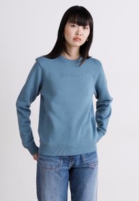 Sudadera azul de mezcla de algodón con un logo texturizado de Lacoste en el pecho, cuello redondo y puños y dobladillo acanalados.