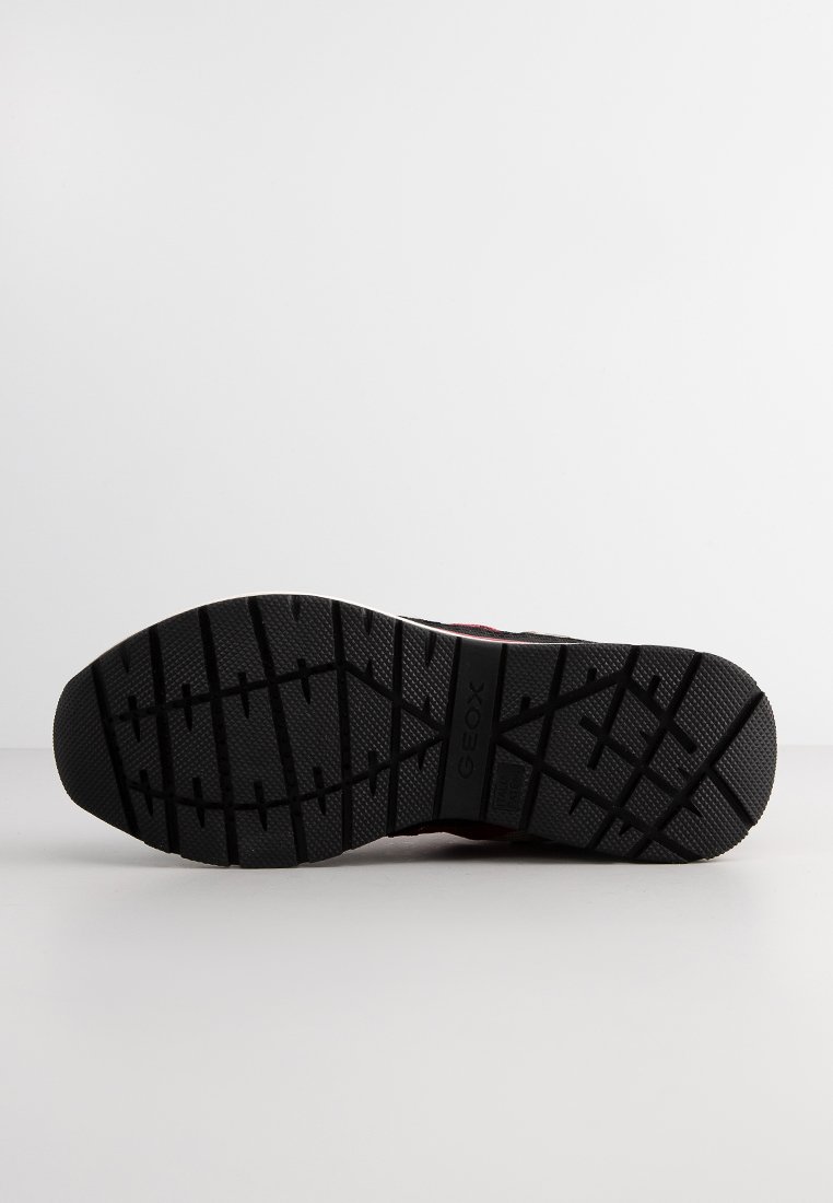 Czarna gumowa podeszwa buta z teksturowanym wzorem bieżnika i widocznym brandingiem "GEOX" na środku, na białym tle.