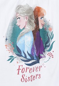 Maglietta grafica con personaggi illustrati dai capelli biondi e rossi, circondati dalla vegetazione. Il testo sottostante recita "Sorelle per Sempre" in rosso.