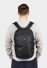 Black backpack made of durable fabric, featuring multiple zippered compartments, adjustable straps, and ergonomic design. Compact and functional.