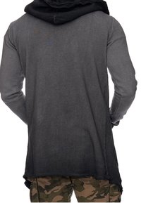 Langsleeve hoodie in een gradiënt van grijs naar zwart, met een versleten zoom en een grote, textuur kap. Gecombineerd met camouflage shorts.