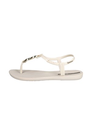 Sandalias tipo thong blancas con una plantilla texturizada, tiras delgadas y un acento de cadena dorada en la parte superior. Suela plana con un diseño minimalista.
