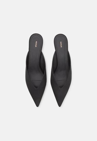 Mules pretas de bico fino em tecido suave com um design elegante e costas abertas. Apresentam um salto baixo e um detalhe de costura subtil nas laterais.