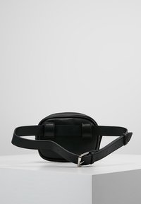 Sac de taille en cuir noir de forme rectangulaire, avec une sangle de ceinture ajustable et deux accents de boucle. Texture lisse et sans motifs visibles.