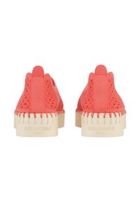 Calzature color corallo con una parte superiore strutturata, design decorativo a taglio laser e suola di gomma color crema con bordi seghettati e branding.
