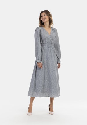Lichtblauwe bloemenmaxi-jurk met lange pofmouwen, een diepe V-hals en gerimpelde taille, gecombineerd met blush hakken.