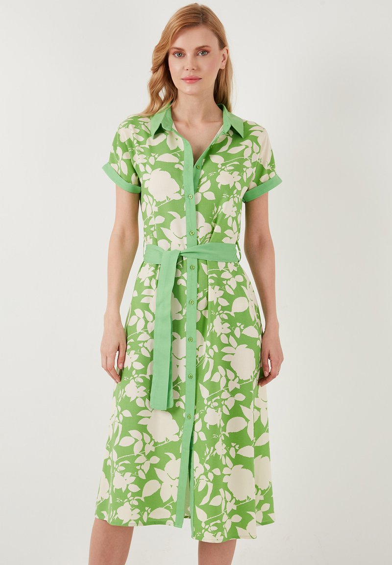Grünes Hemdkleid mit weißen Blumenmustern, durchgehender Knopfleiste, kurzen Ärmeln mit Cuff-Akzenten und einem passenden Gürtel.