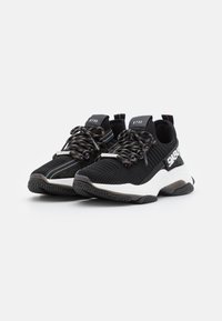 Scarpe sportive nere con parte superiore in mesh, lacci testurizzati con accenti arcobaleno, suola intermedia spessa bianca e suola in gomma con battistrada a motivo.