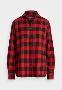 Röd och svart rutig långärmad skjorta med krage, som har en liten broderad logotyp på vänster bröst.